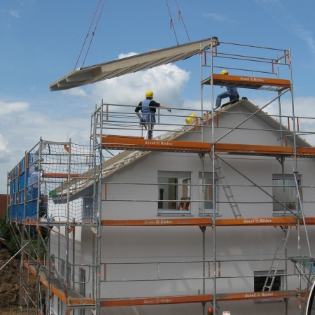 Un chantier de construction d'une maison avec un échafaudage et une grue