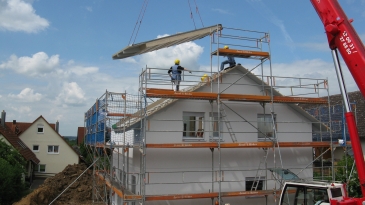 Un chantier de construction d'une maison avec un échafaudage et une grue