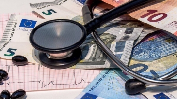 Photographie d'un stetoscope, de pilules, d'un électrocardiogramme et de billets en euros pour illustrer le coût de la qualité de l'air intérieur